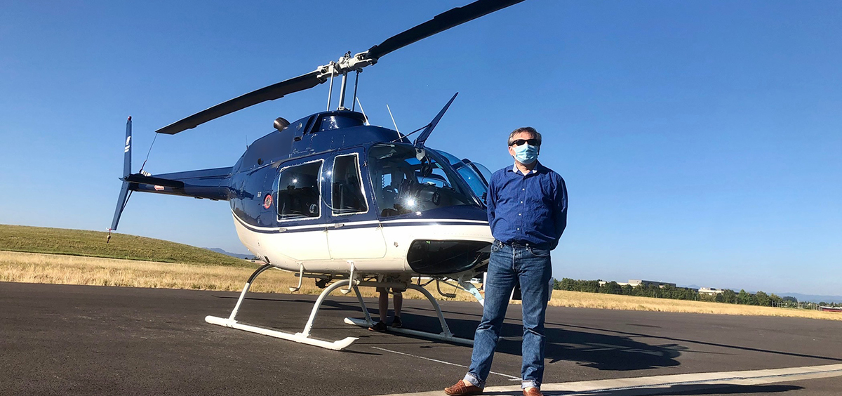 Carlo Tiana standing in front of a helicopter.