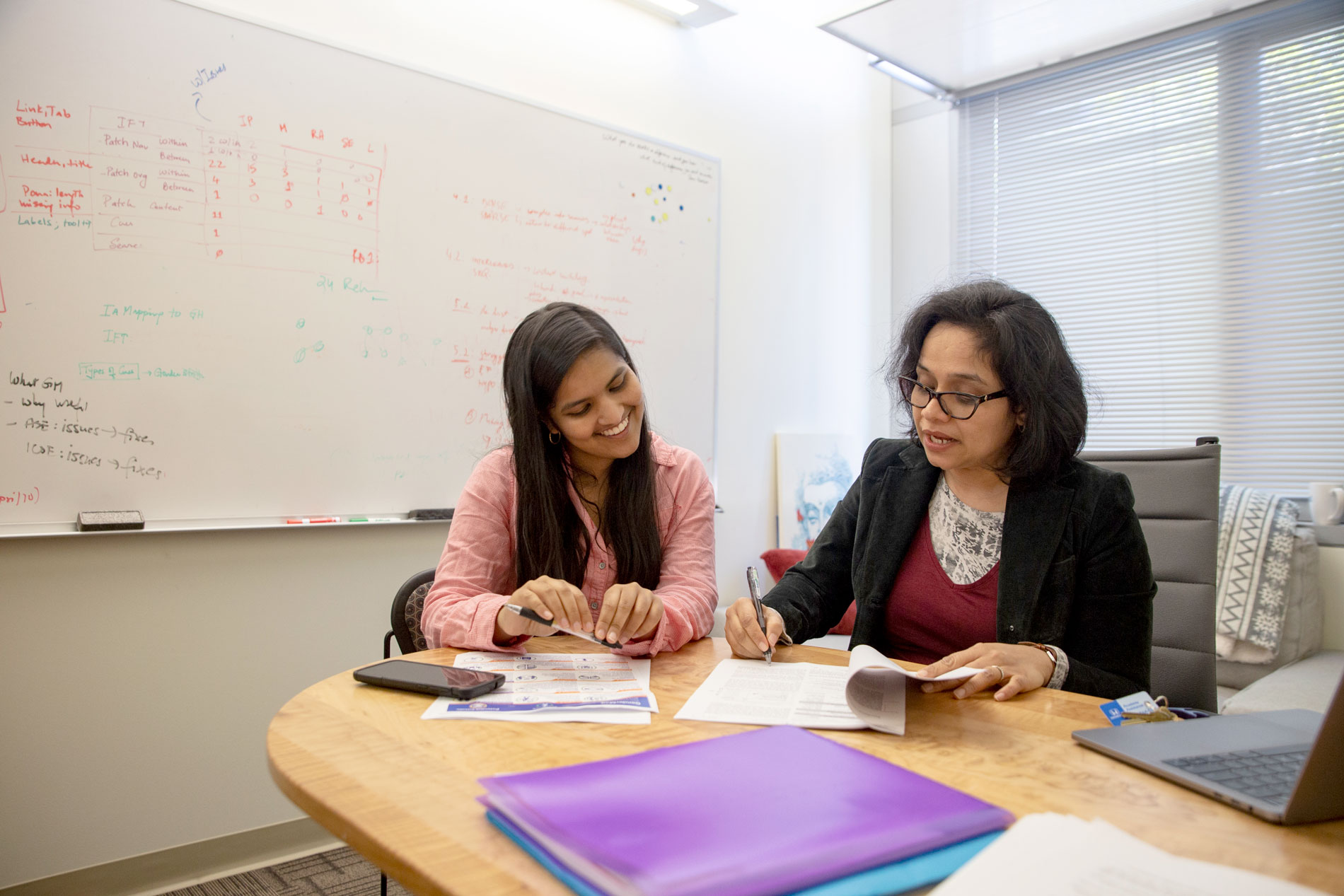 Anita Sarma and student working together at a table.