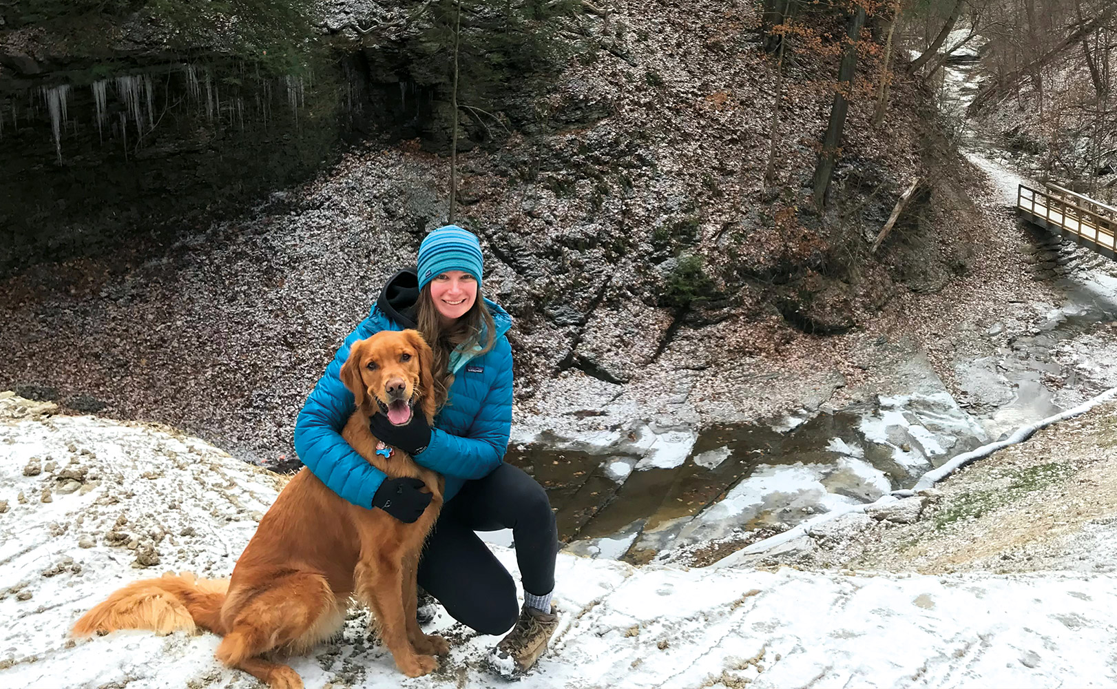 Mary Beth Berkes with their dog in winter clothing.