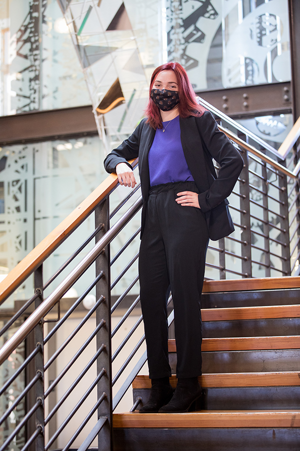 Alex Saccente posing on a flight of stairs in Kearney Hall.
