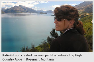 Katie Gibson looks over a lake surrounded by mountains.