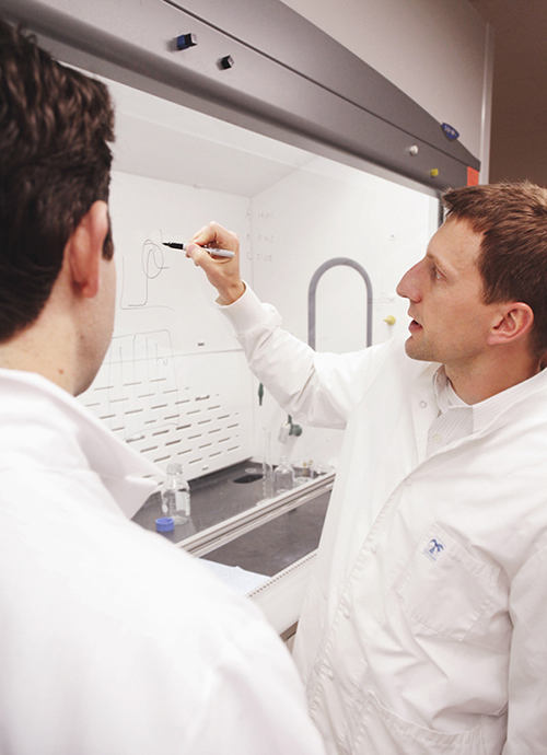Jason Stowers and Stephen Meyers wearing personal protective equipment in a lab.