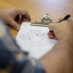 A person drawing a beaver.