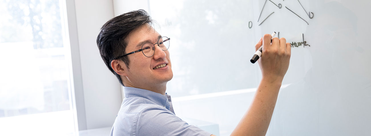 Sanghyun Hong writing something on a whiteboard.