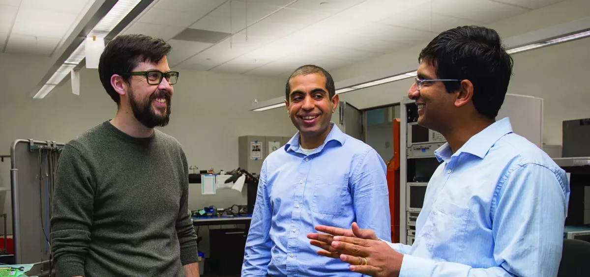 Three faculty members speaking to each other