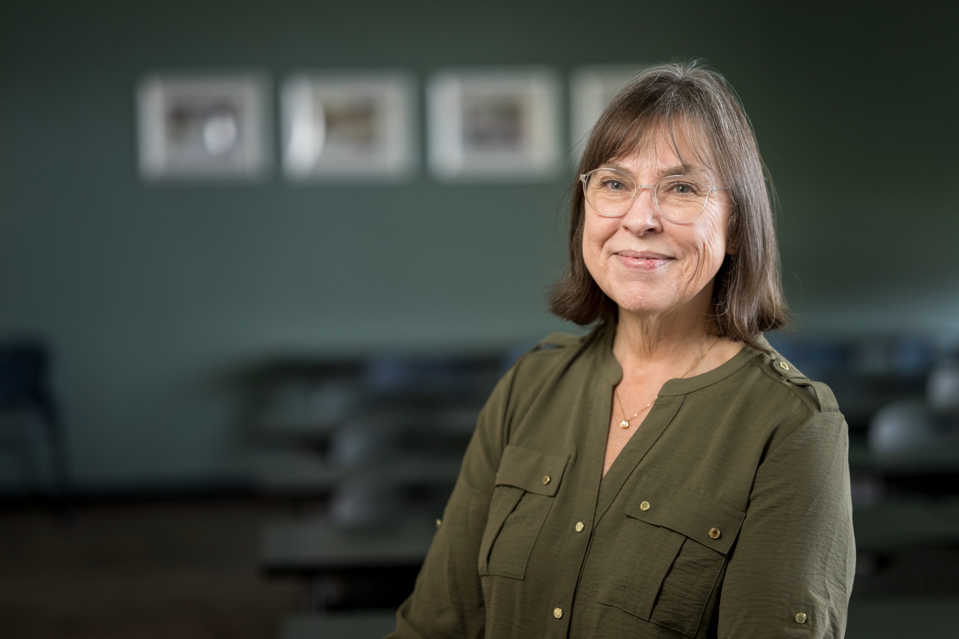 A portrait of a faculty member sitting in a nuclear engineering facility looking at the camera.