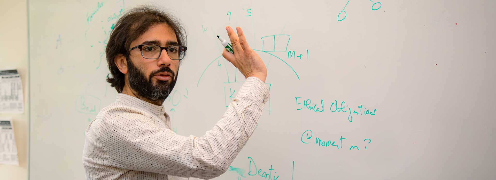 Oregon State Professor Houssam Abbas explaining engineering principles using on a whiteboard