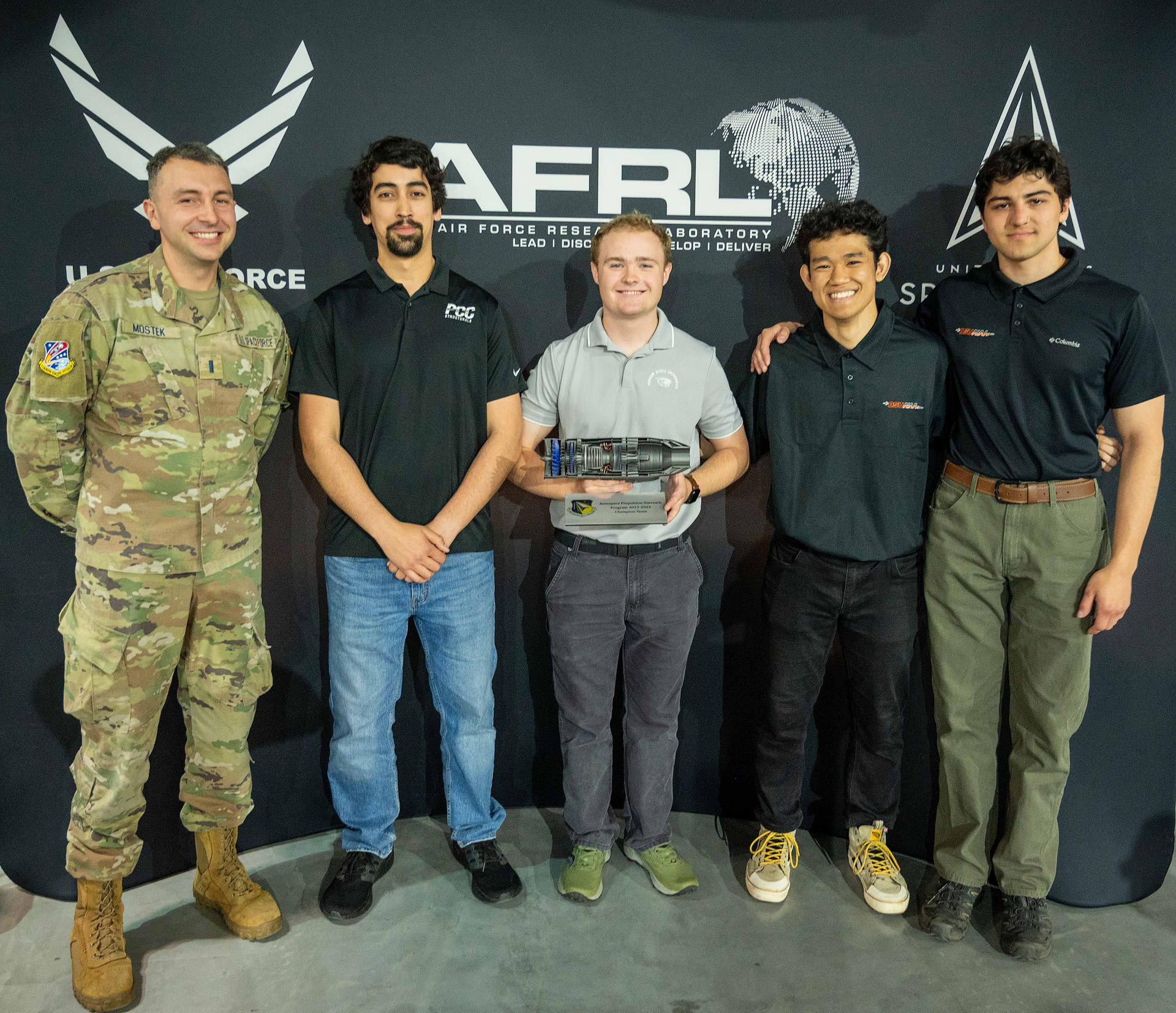 Aerospace engineering students holding a first place trophy for their design of a reverse thruster in a U.S. Air Force competition.