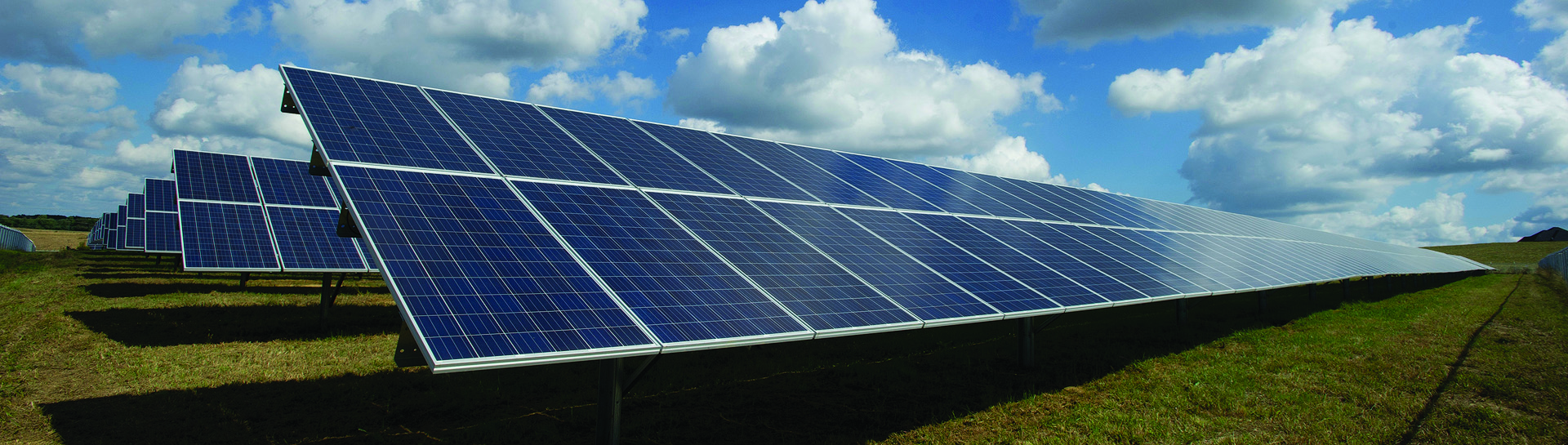 A field with several rows of solar panels.