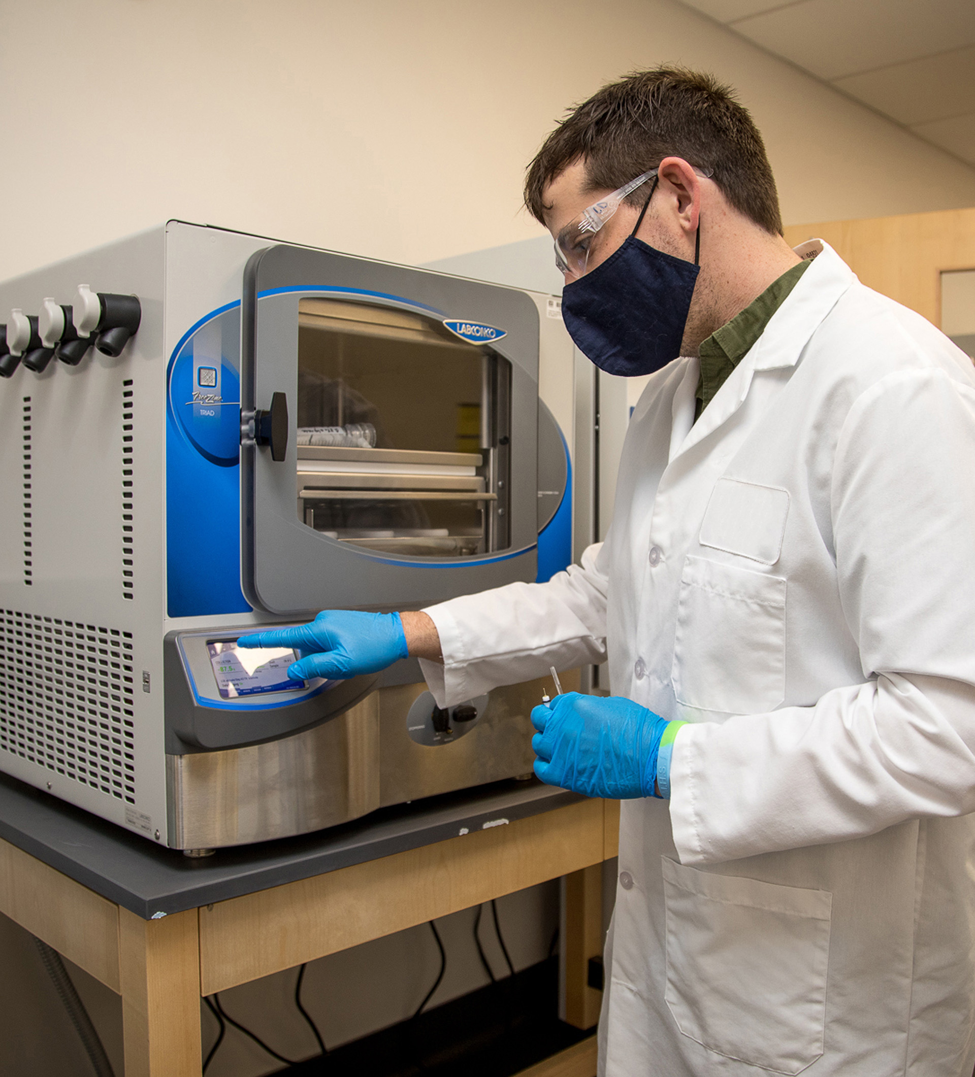 A bioengineering student operating a biomedical prototyping device.