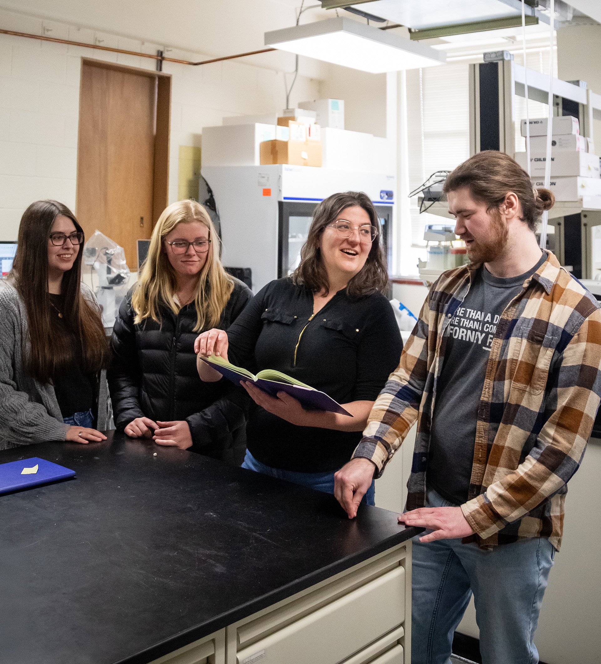 Bioengineering professor Kaitlin Fogg having a discussion with three graduate students.