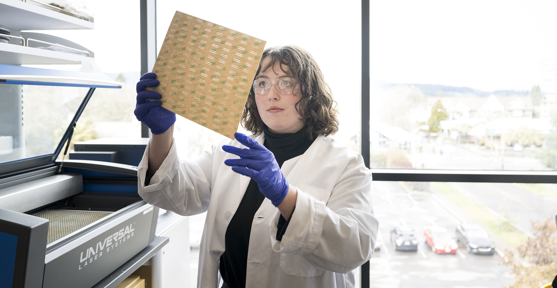 A bioengineering student working with a laser material processing system in the lab.