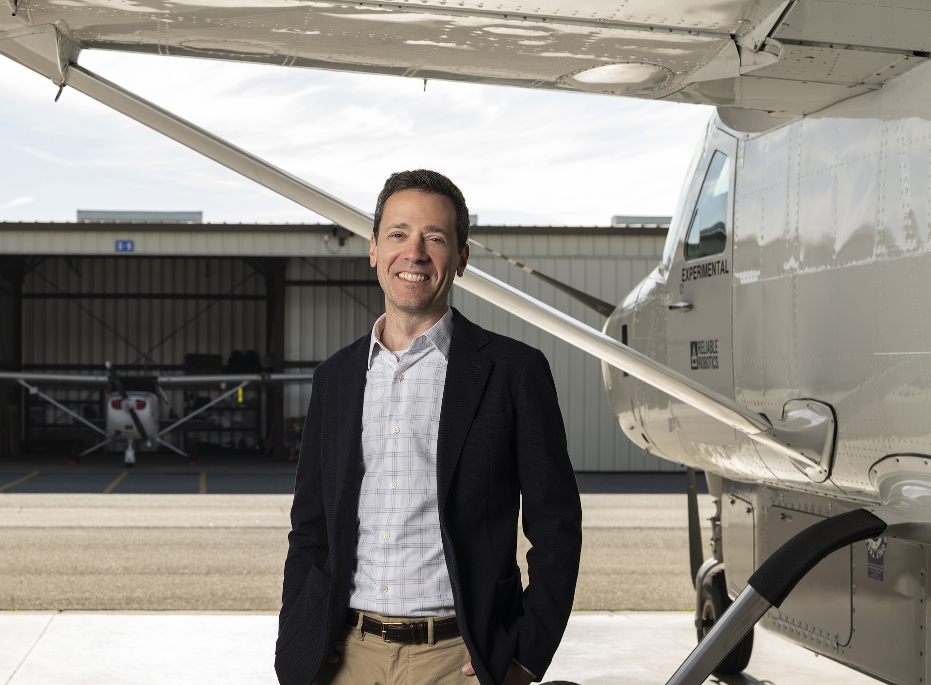 Computer science alumni Robert Rose posing next to a small-sized aircraft.