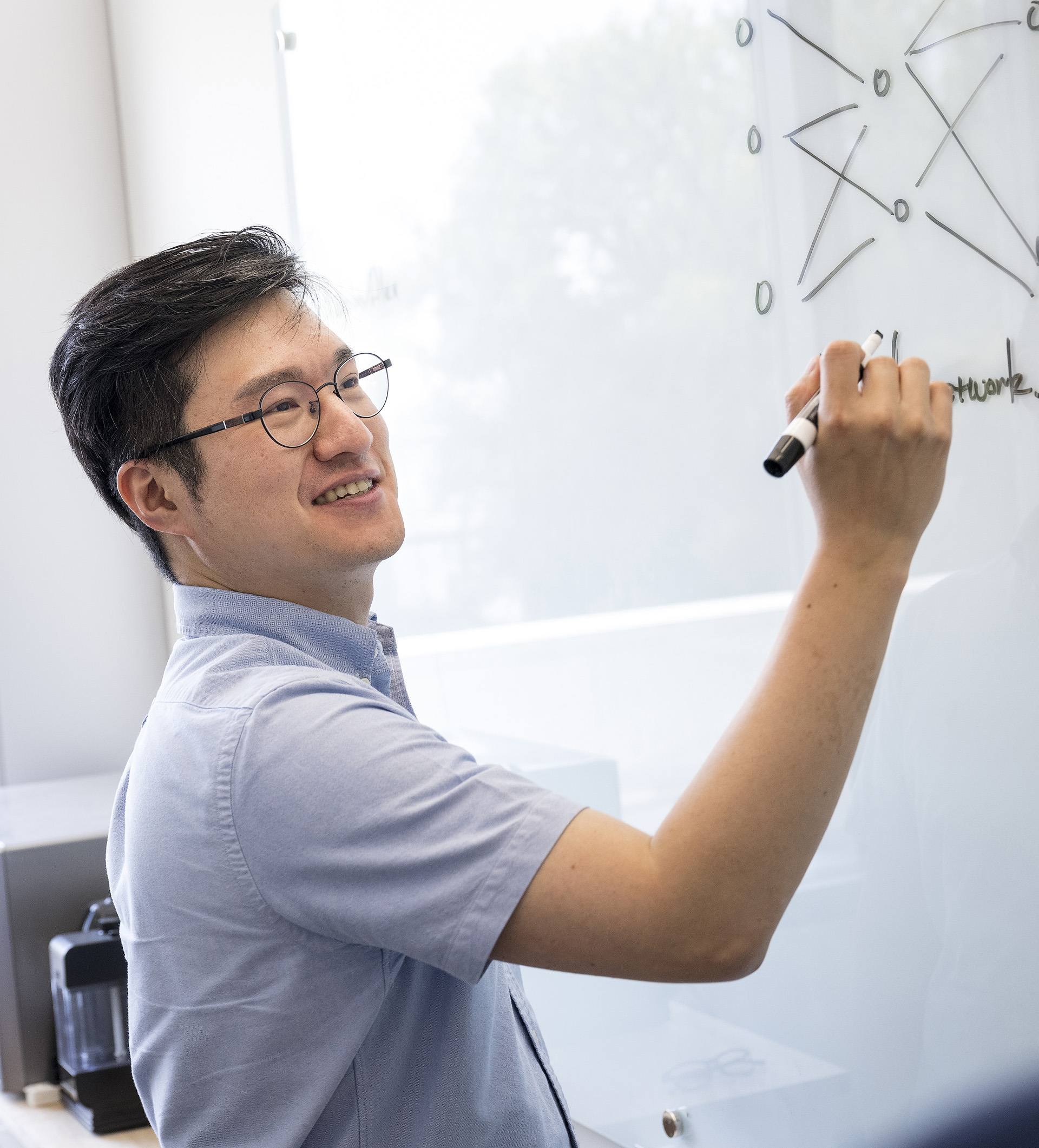 Computer science professor Sanghyun Hong writing on a whiteboard.