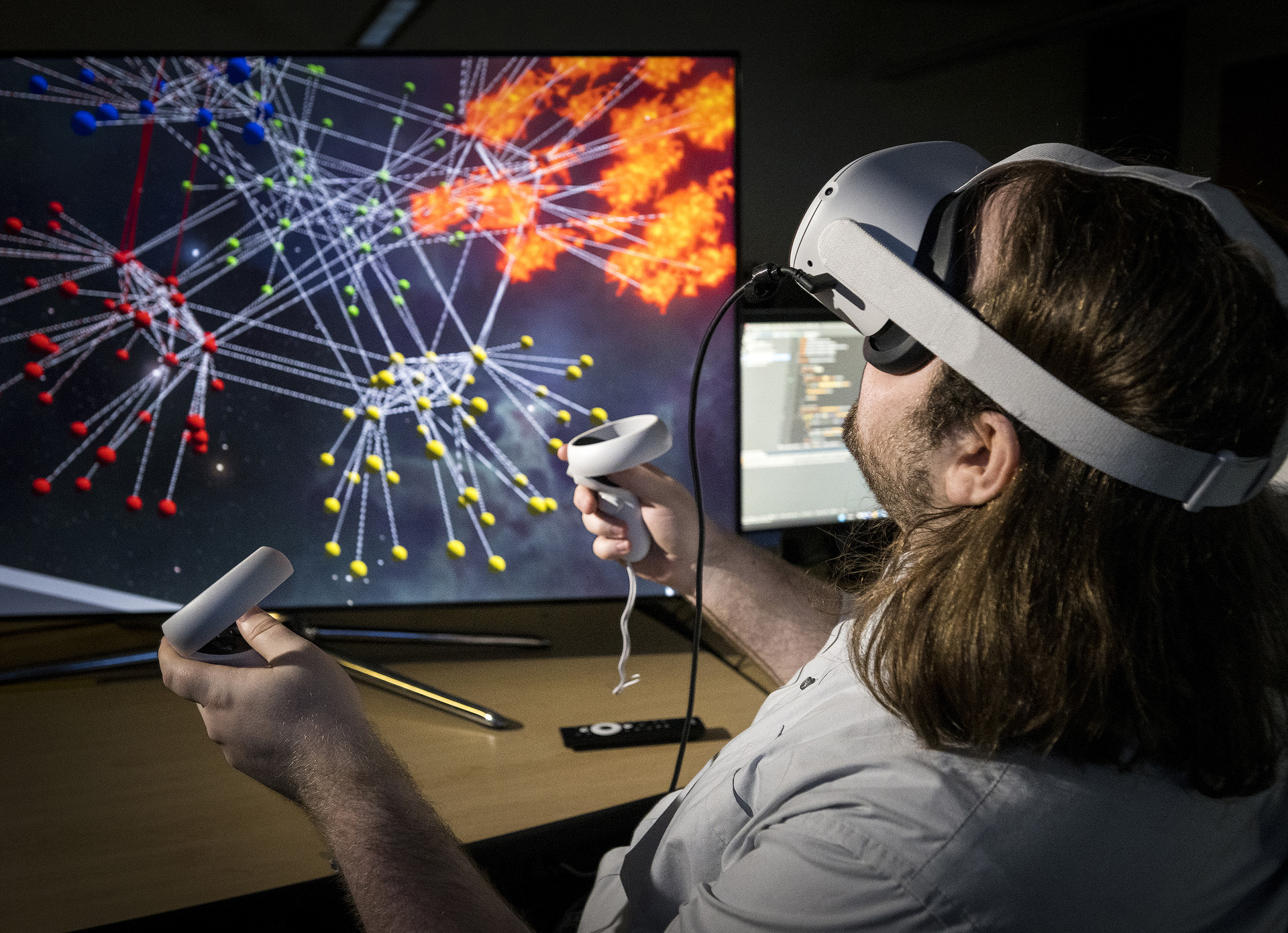 A computer science student manipulating 3d models via a virtual reality headset and controllers.