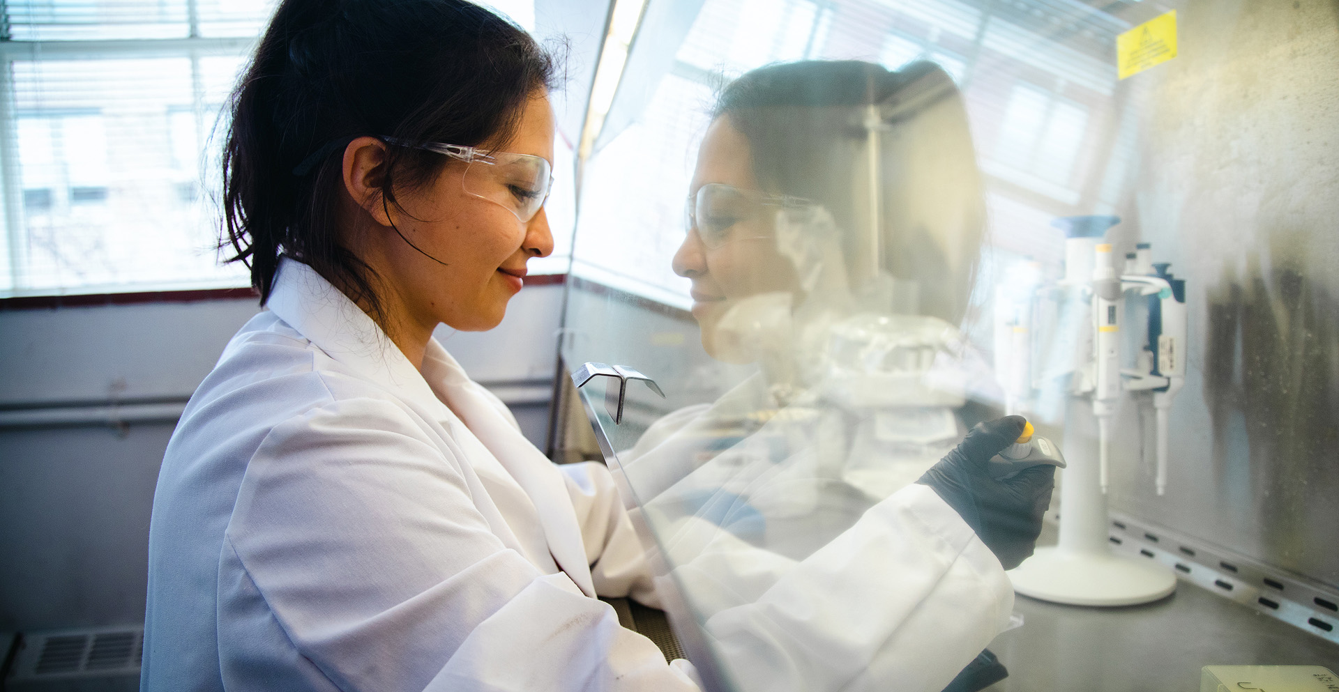 A student pipetting test samples in the laboratory.