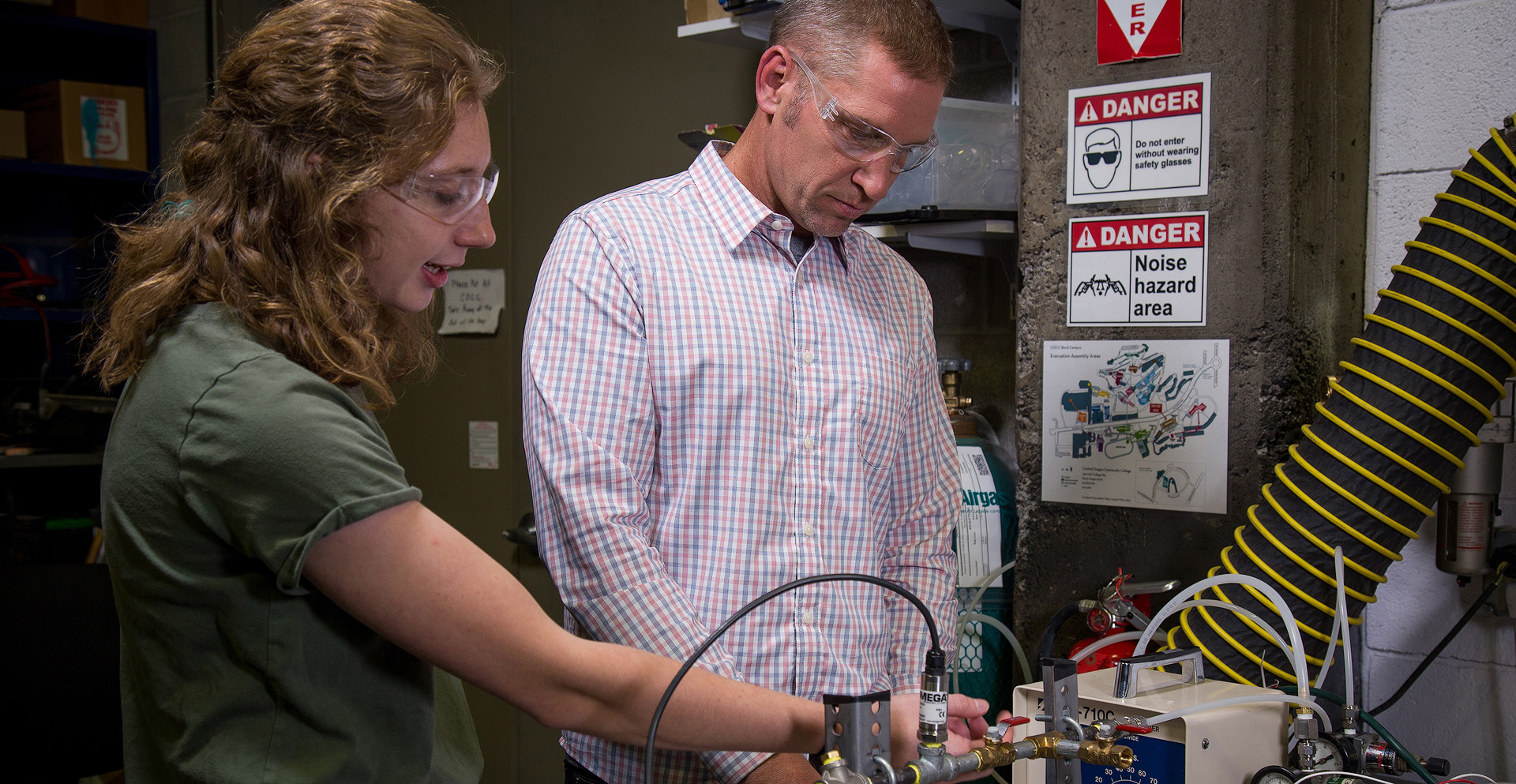 Chris Hagen, professor of Energy Systems Engineering, examining some lab equipment with a student.
