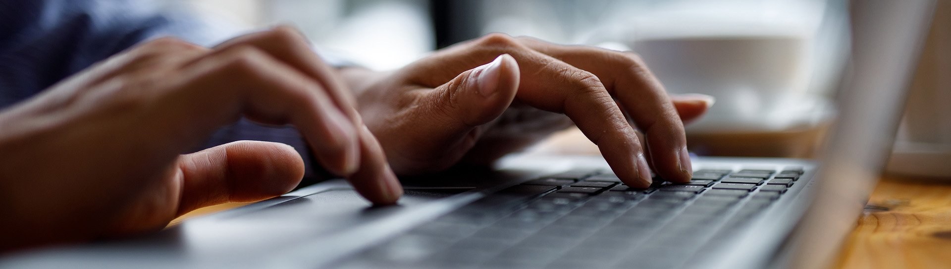 A pair of hands typing on a laptop.