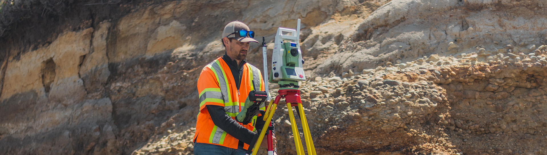 An engineer conducting a land survey with a camera.