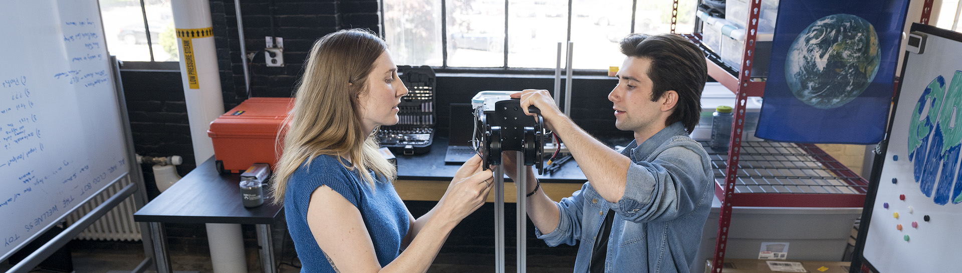 Robotics professor and student working on a piece of robotics component.