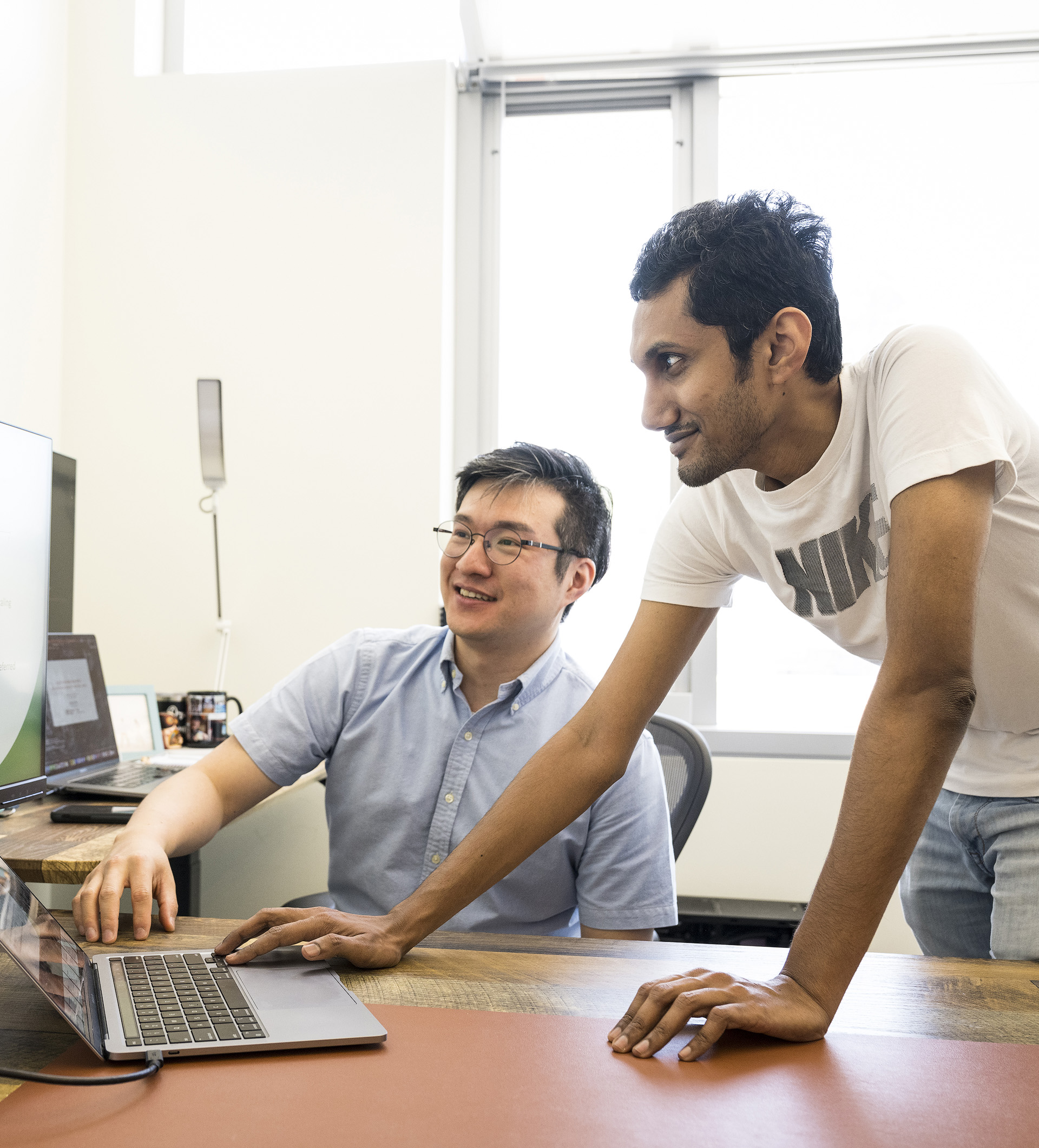 Computer science professor Sanghyun Hong watching a student type on a laptop.