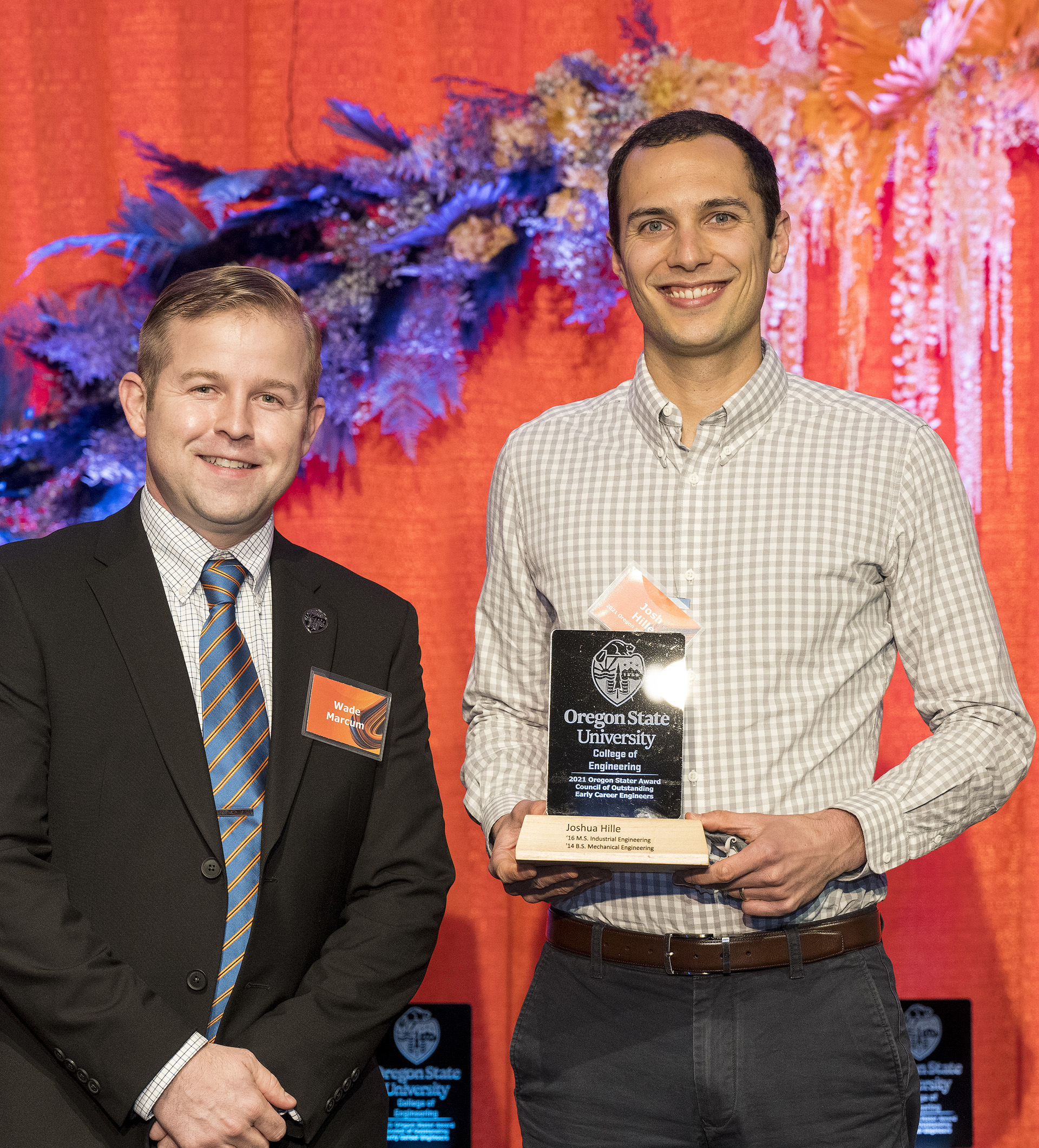 Industrial engineering alumni Josh Hille posing for a photo with an award in hand.