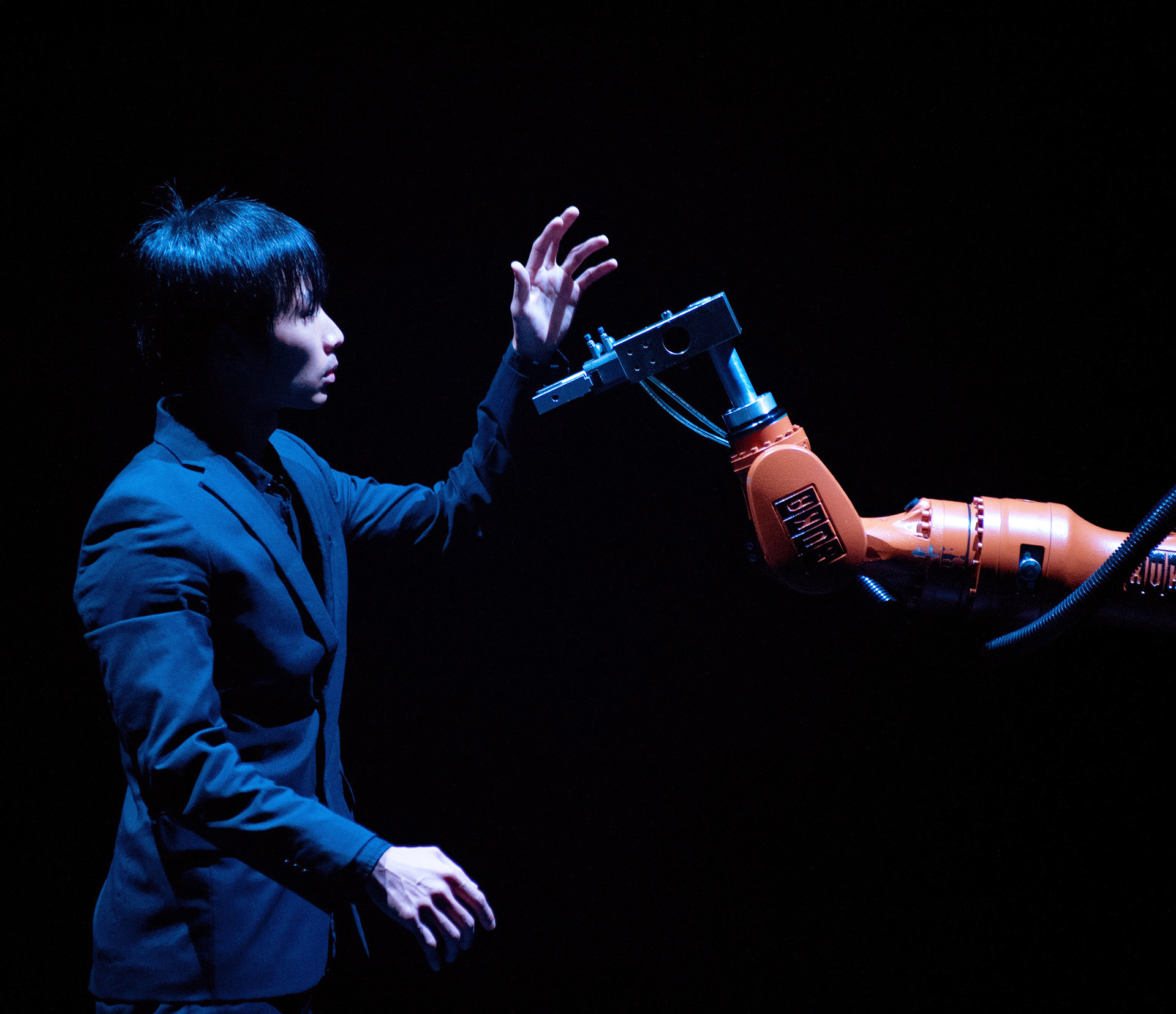 Huang Yi Kuka interacting with a robotic arm during a robotics seminar.