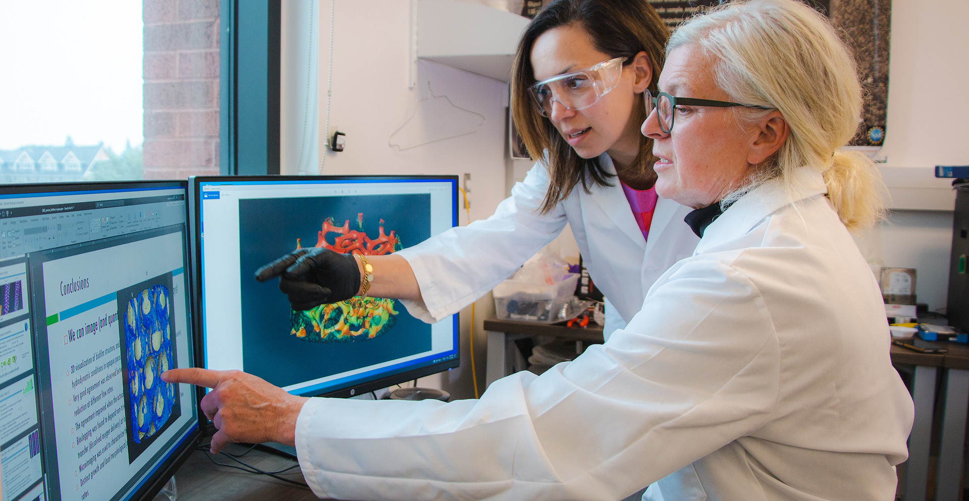 Dorthe Wildenschild and Tala Navab-Daneshmand, professors of environmental engineering, analyzing data visualizations on a computer.