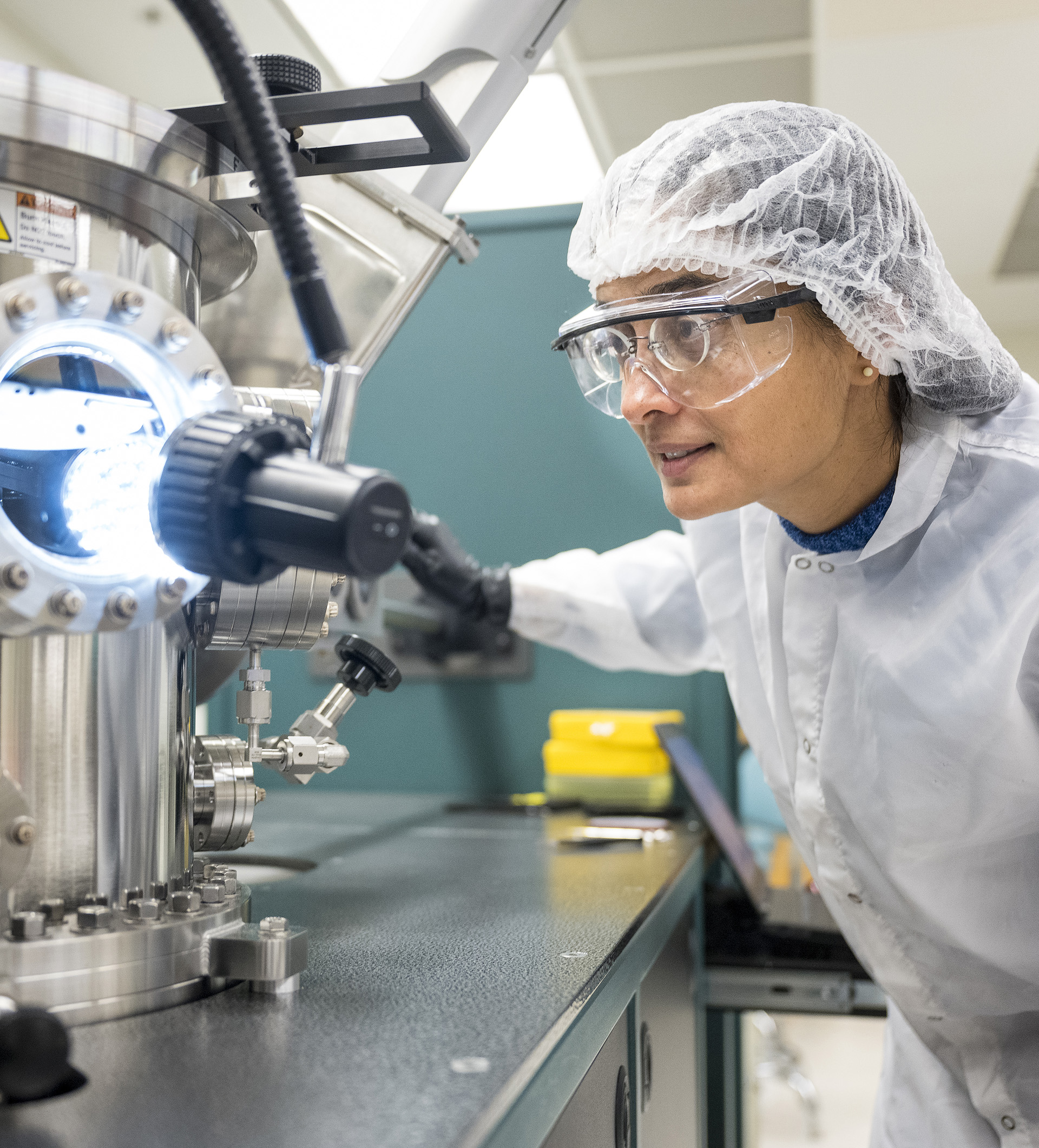 Faculty member examining a semi conductor tool