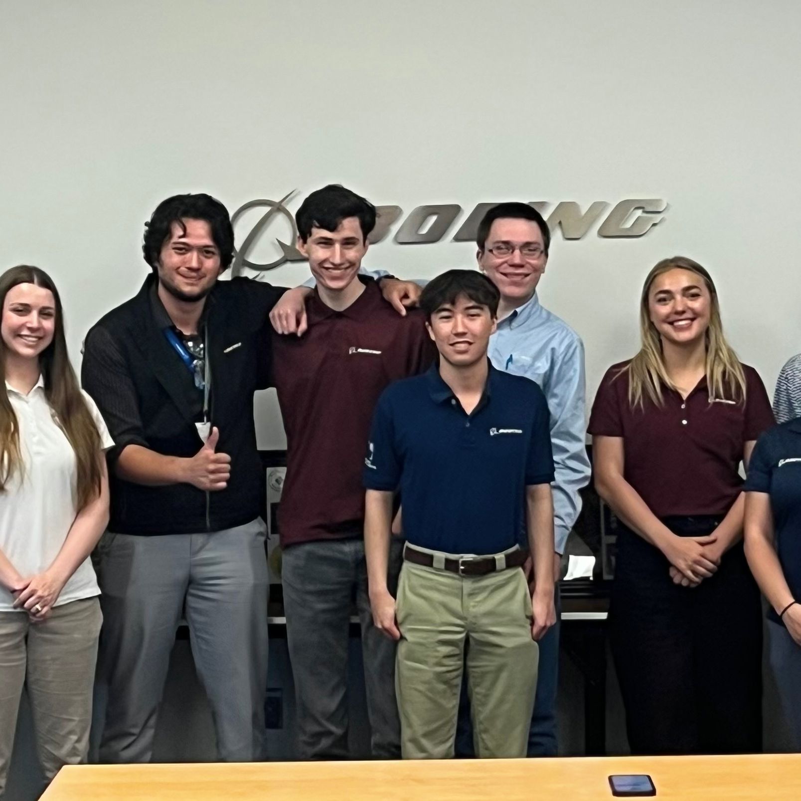 OSU-Boeing partnership group posing in front of a Boeing wall sign.