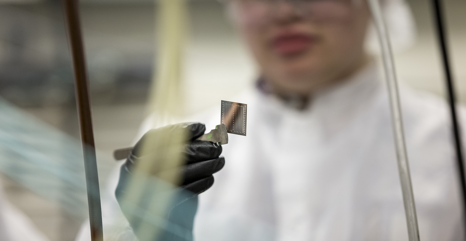 Research holding a steel microchip template.