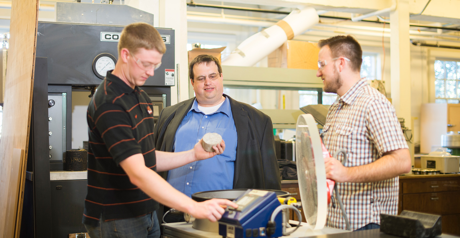 Two students working with a professor.