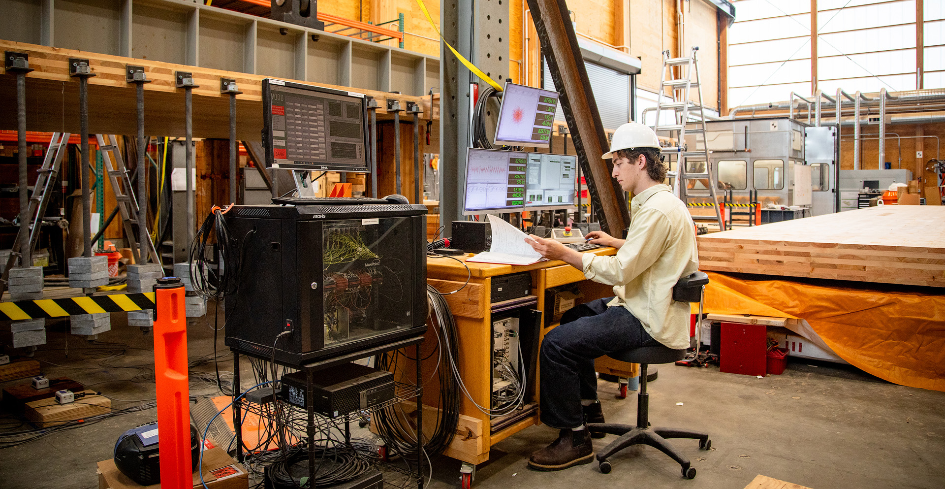 A man working at a desk in front of monitors.