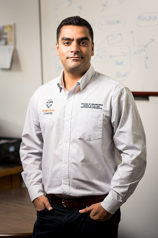 Professor Joseph Louis in a button-down shirt stands confidently with hands in pockets before a whiteboard, conveying an approachable, academic tone.