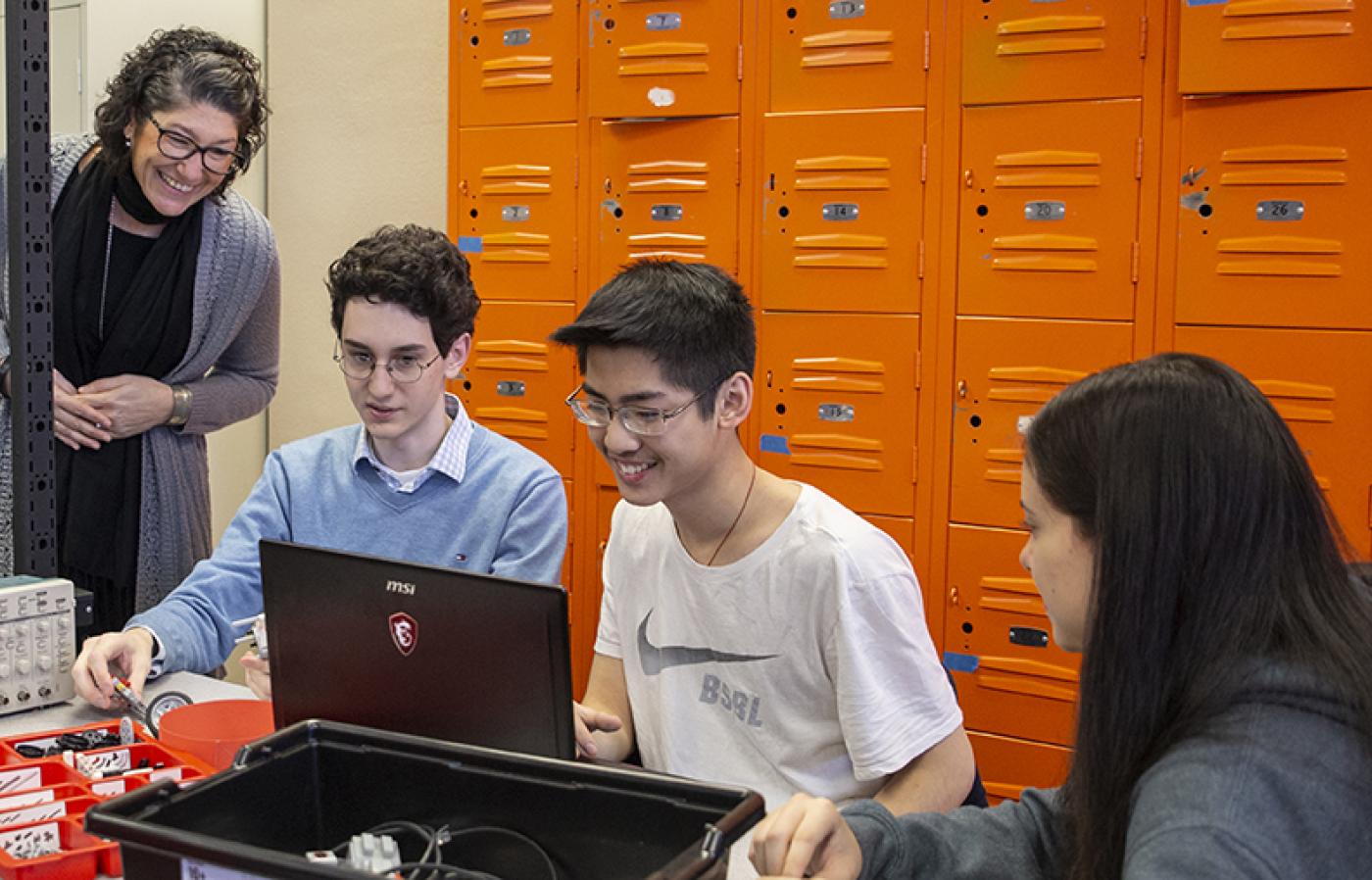 Jennifer Parham-Mocello oversees a group of three high school students working on a project.