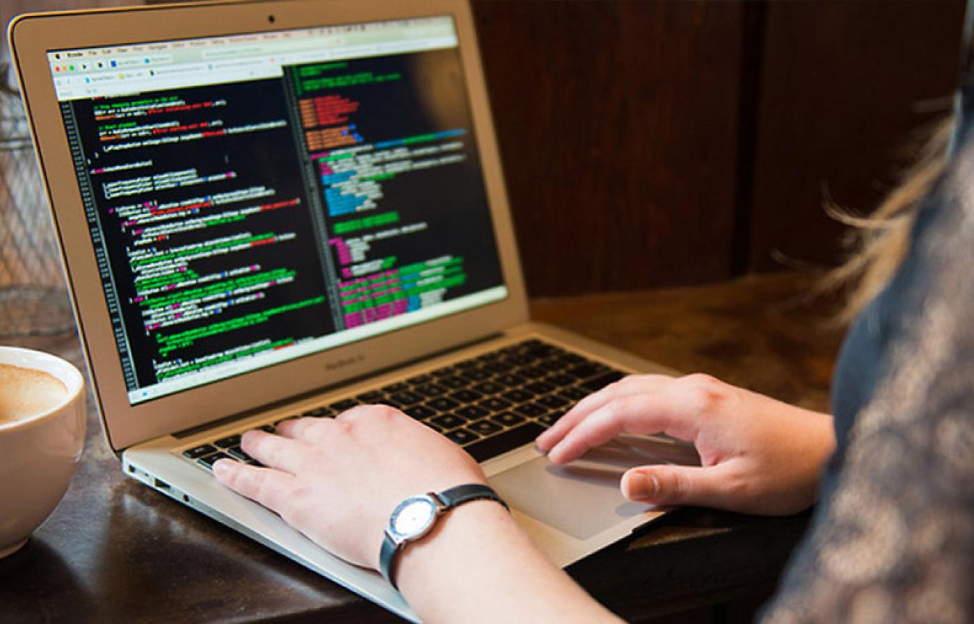 A student programming on a laptop.