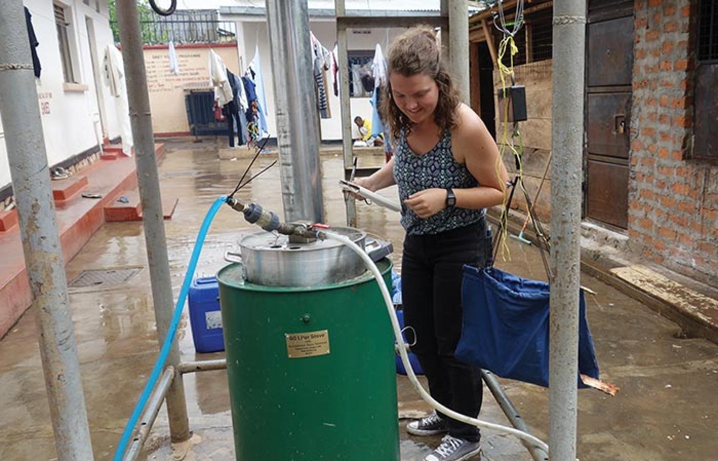 Graduate student Grace Burleson records measurements from an InStove Water Purifier in Uganda.