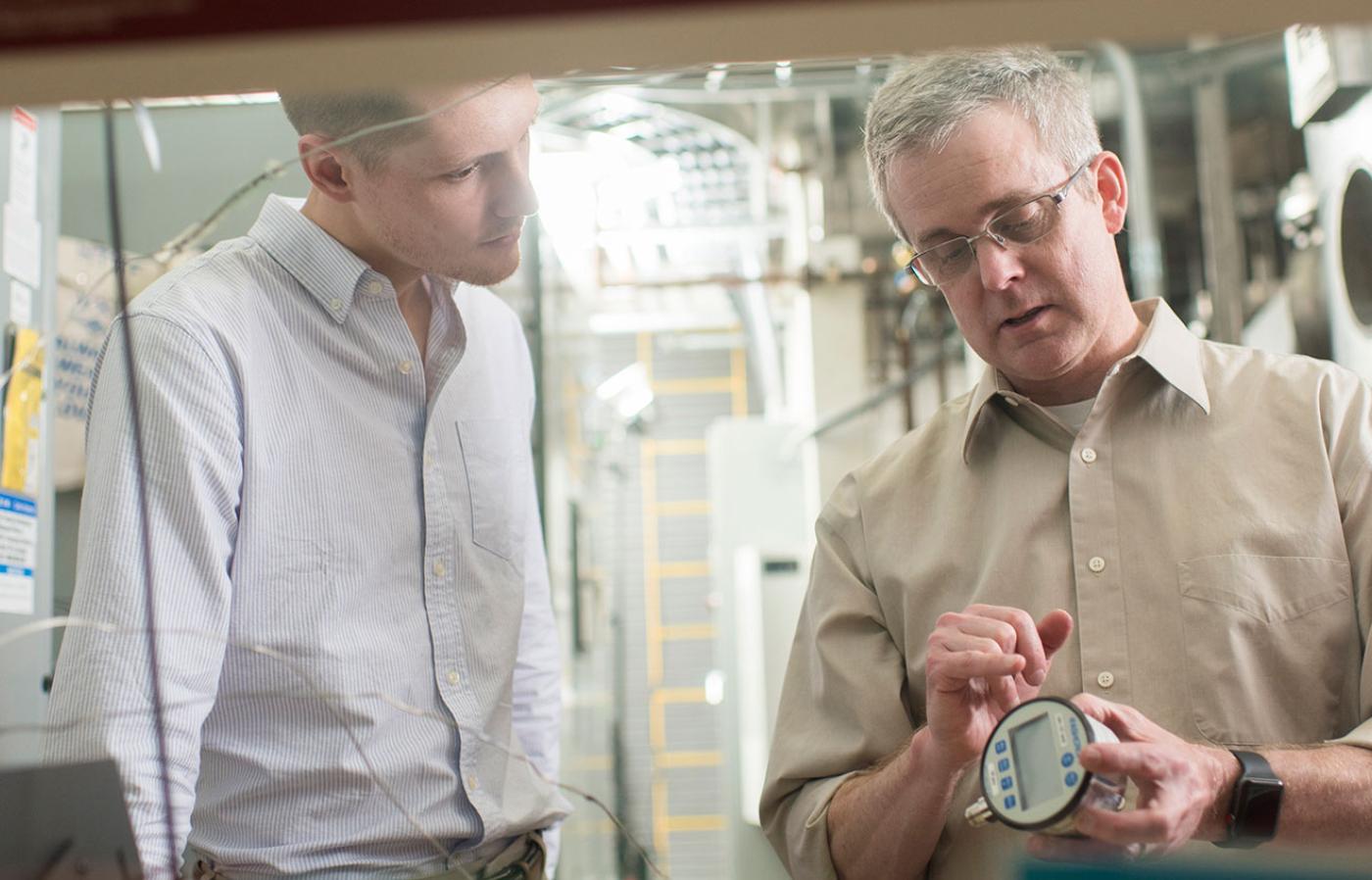 Brian Woods teaching a nuclear engineering student about a device.