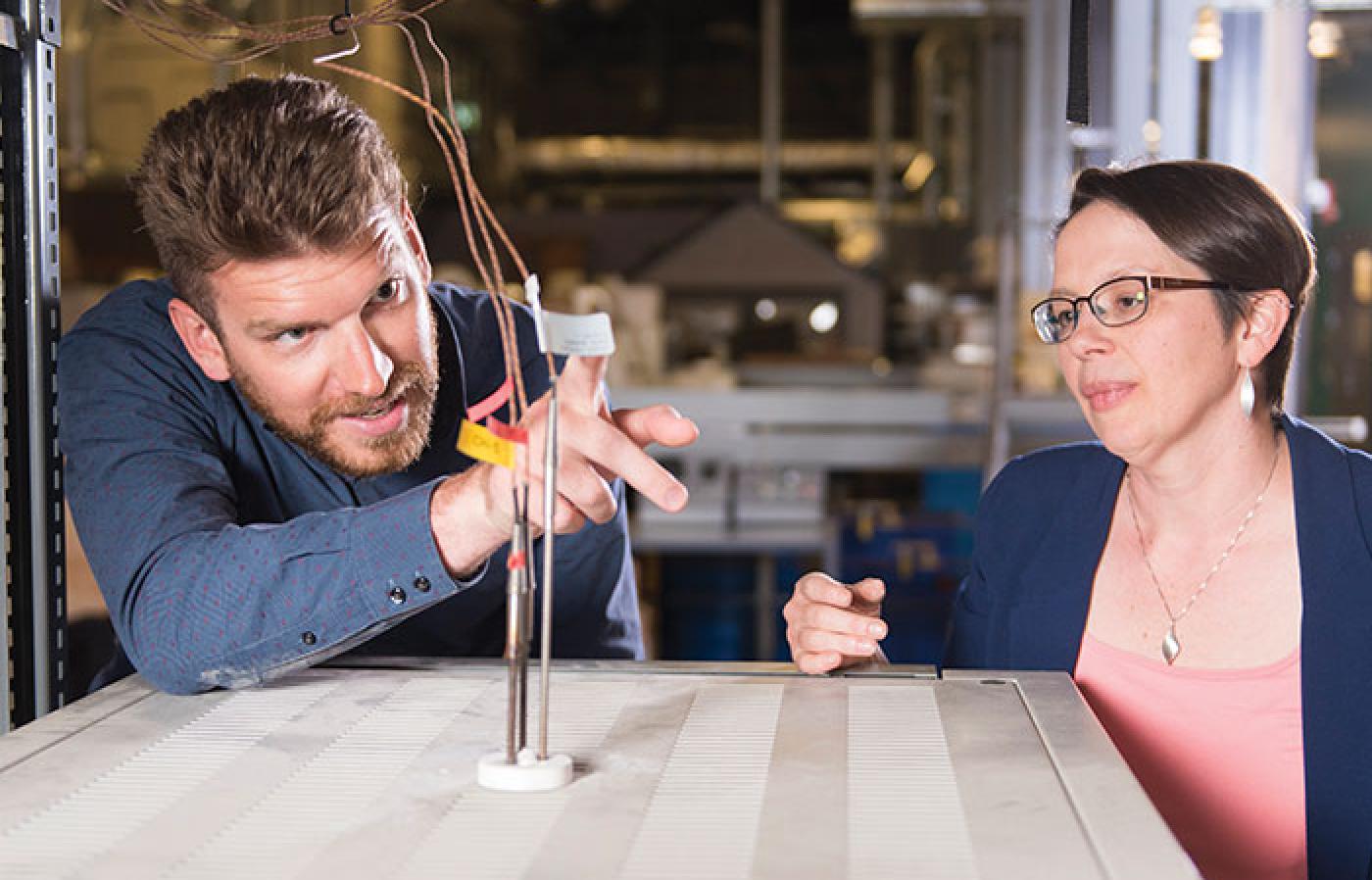 Samuel Briggs and Julie Tucker checking the leads on a nuclear reactor monitoring device.
