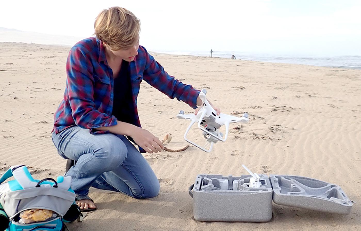 A Coastal and Ocean Engineering doctorate student working on a drone at a beach in Santa Maria Valley.