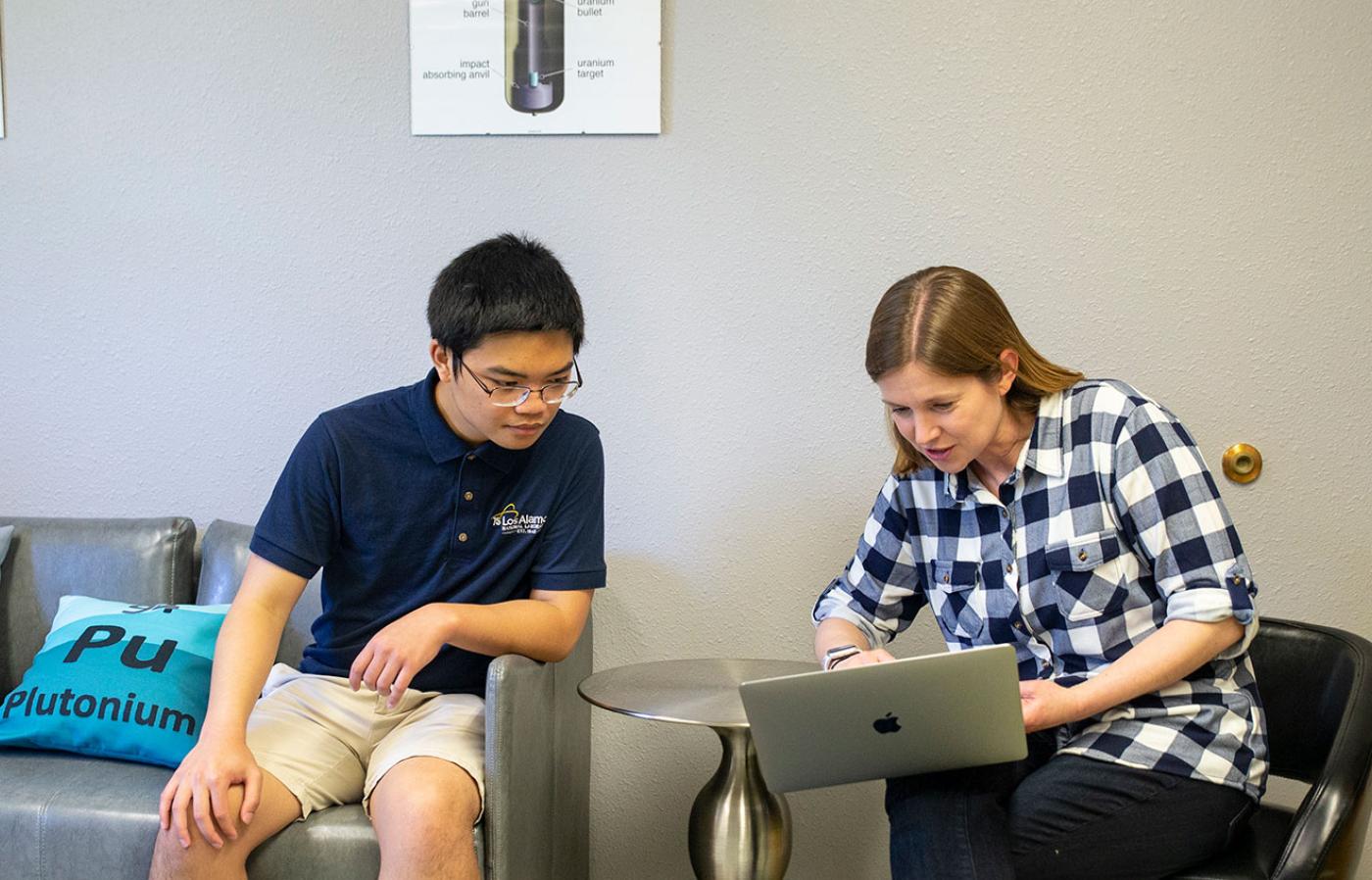 Kyzer Gerez working on a laptop with Camille Palmer.