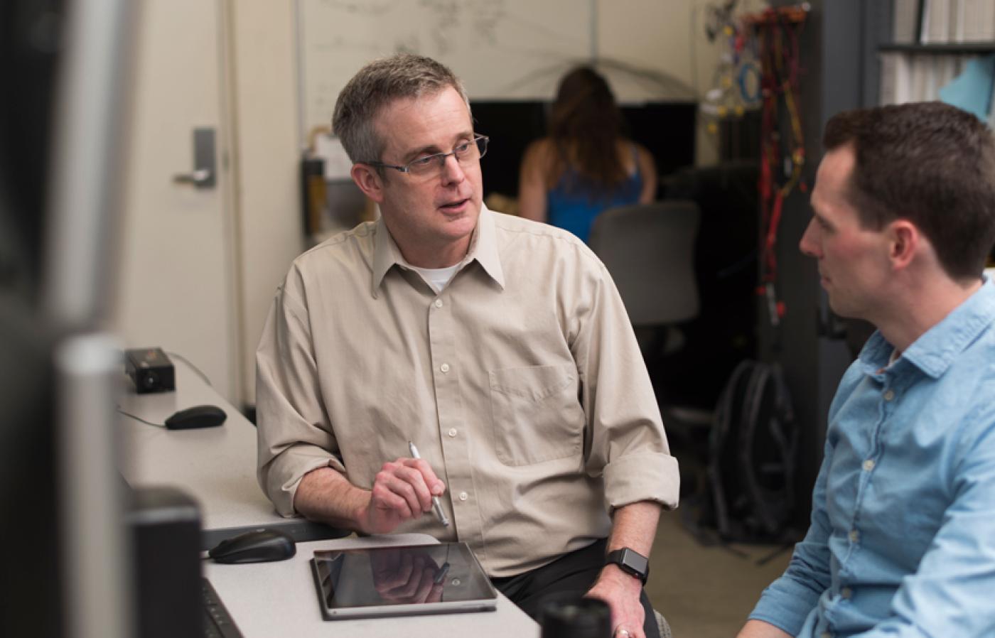 Brian Woods talking to a colleague.