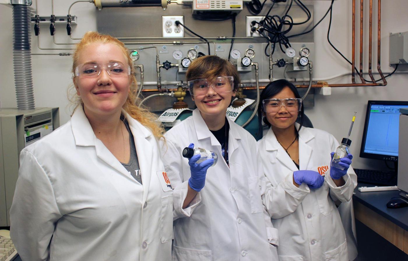 Three students in lab uniform.