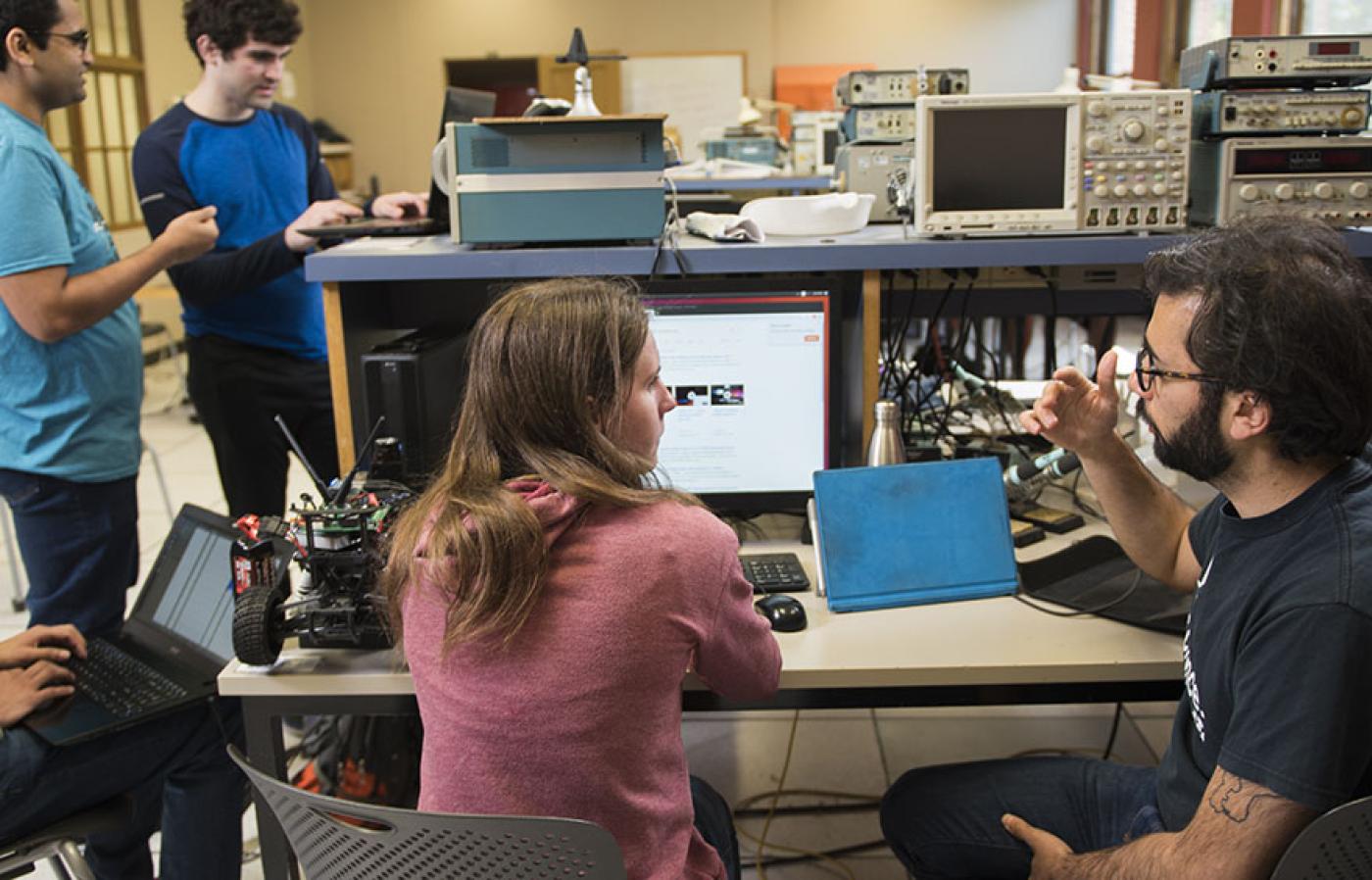 Houssam Abbas working with students on a autonomous race car.