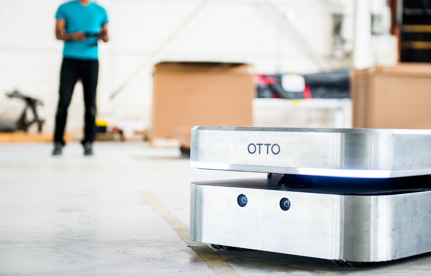 A square Otto robot on a concrete floor.
