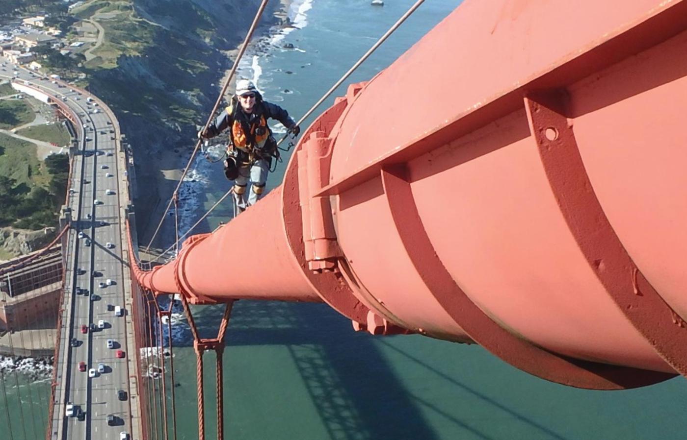 Nick Clark walking on railing of a bridge. 
