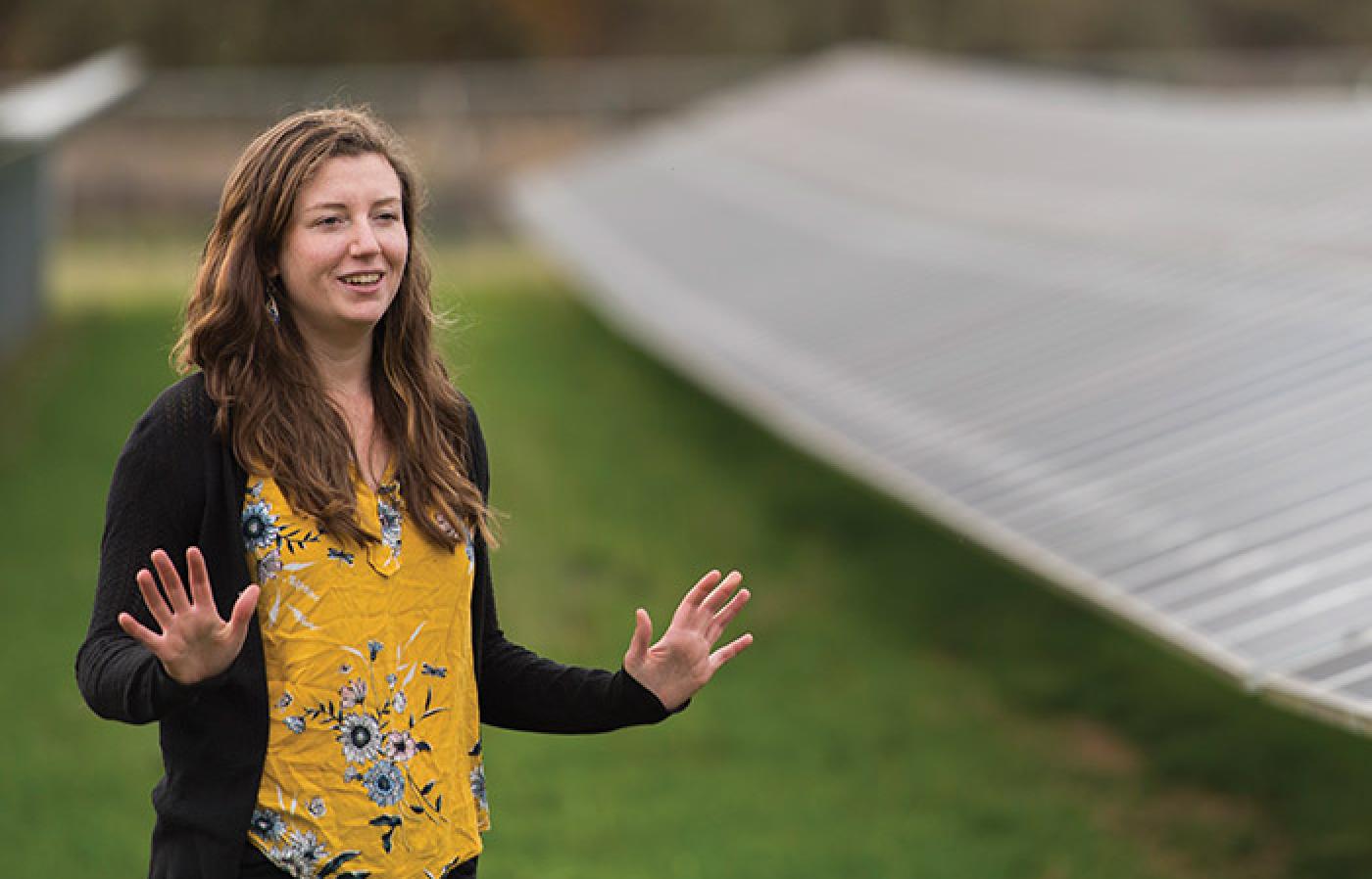 Phylicia Cicilio standing in a microgrid of solar panels.