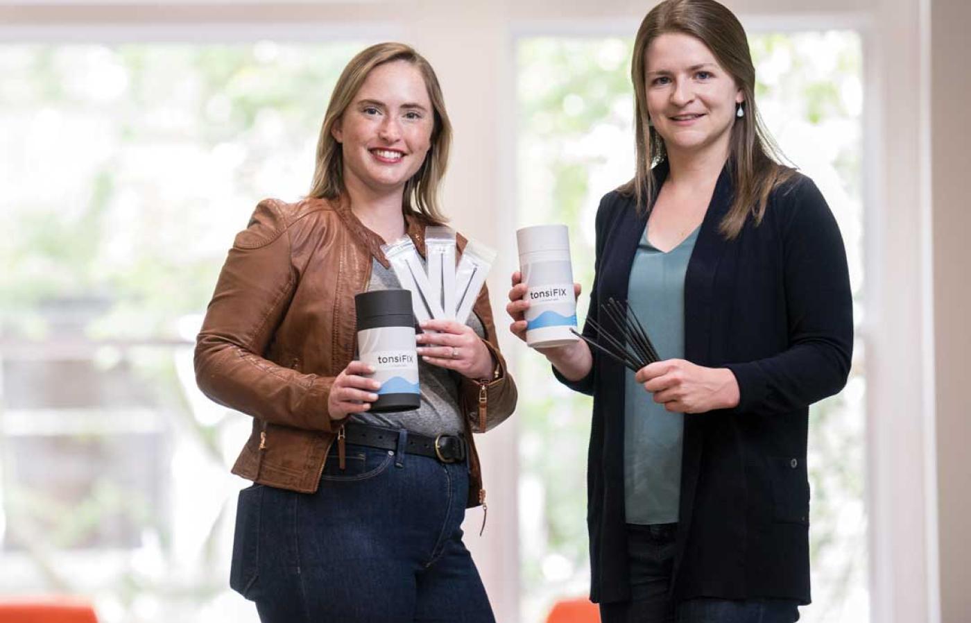 Two engineering members holding their business brand mugs.