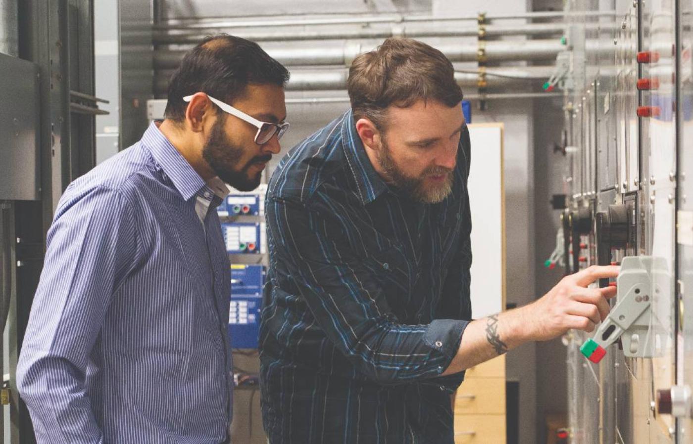 Two people looking at a power generator.