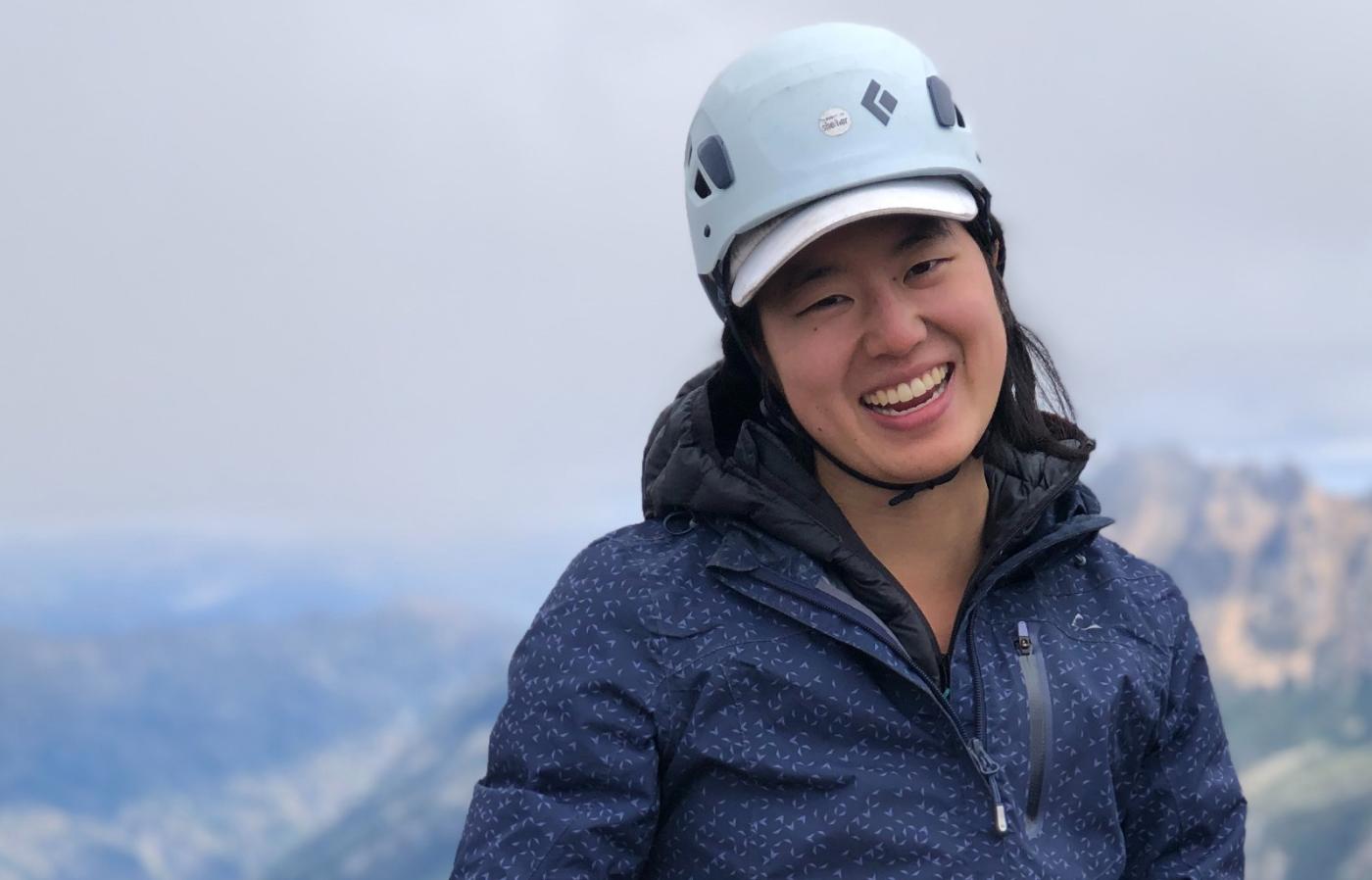 Samantha Kang in hiking gear with mountains in the background